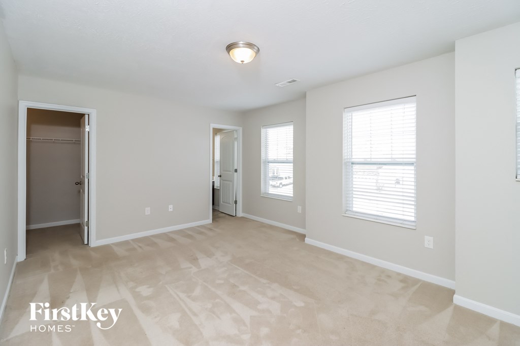 a spacious living room with a door to the closet and a hallway to the bathroom