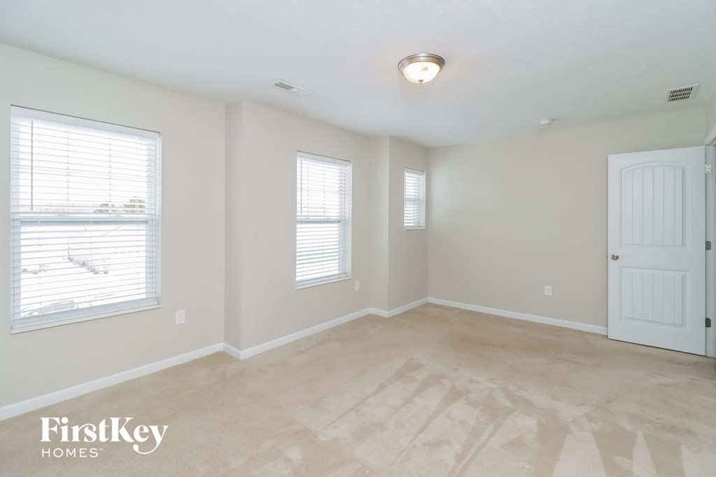 the living room of an empty home with a white door and window