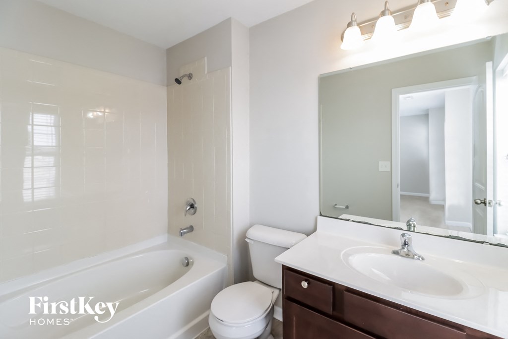a bathroom with a sink toilet and tub and a mirror