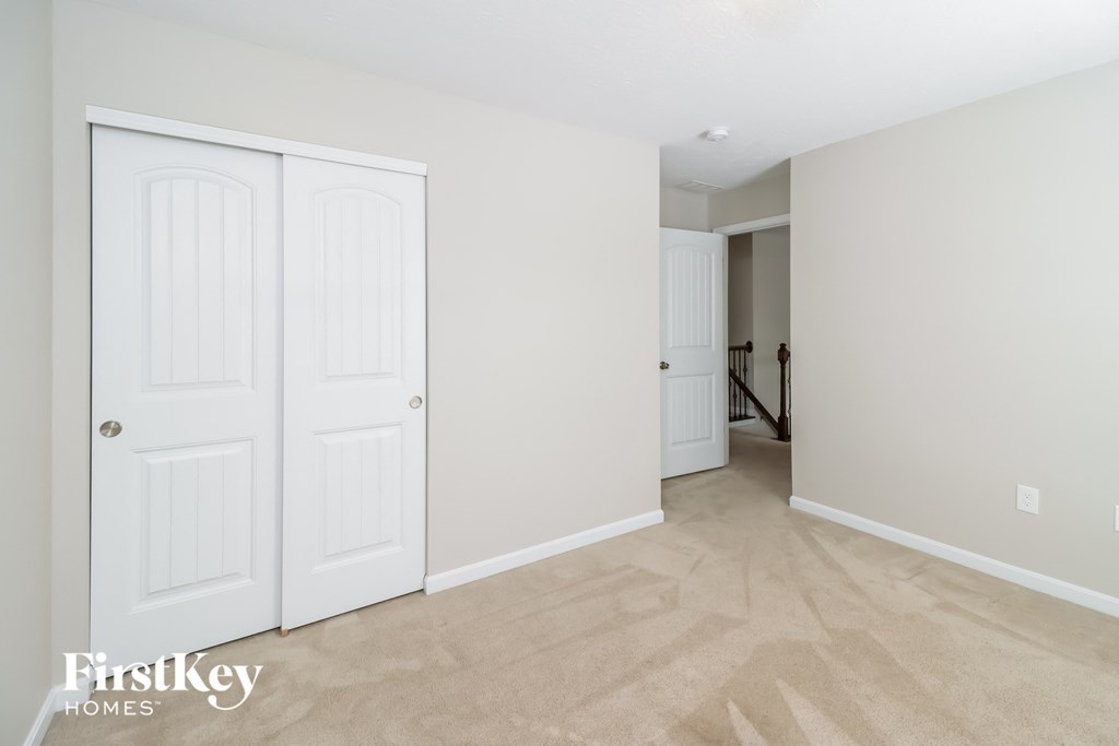 a bedroom with two closets and a door to a hallway