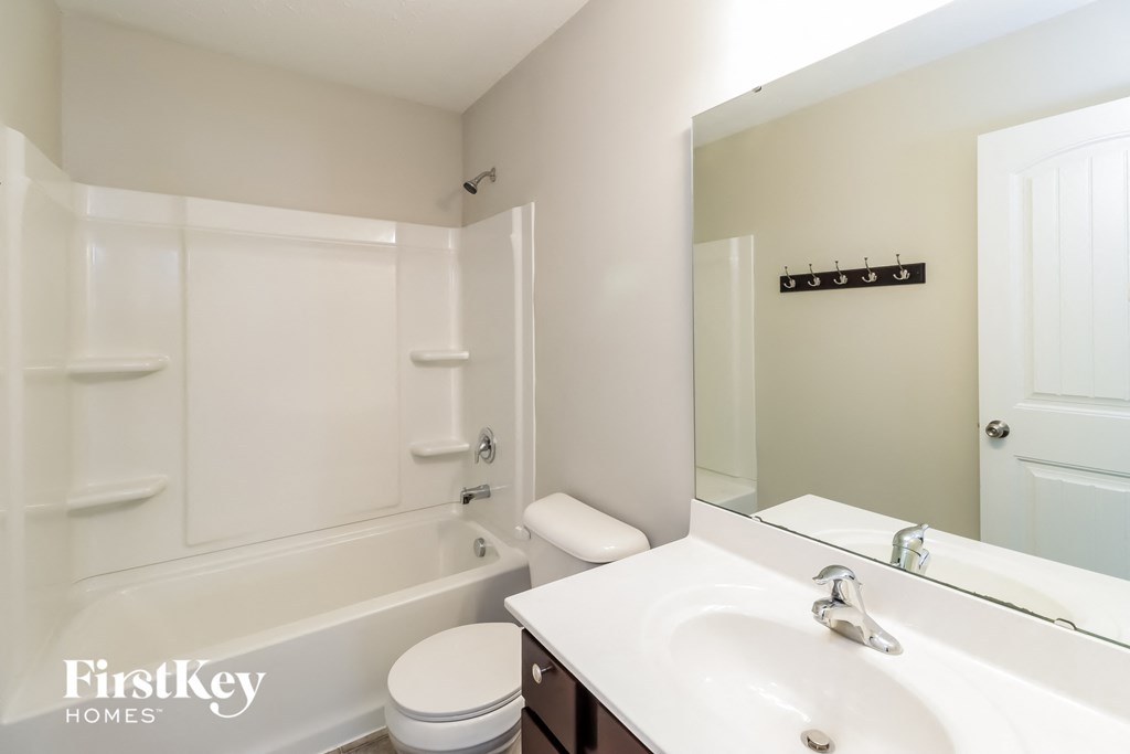 a bathroom with a sink and a toilet and a bath tub