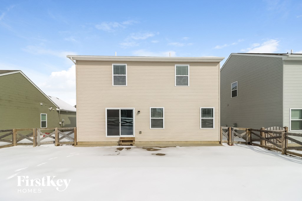 a home with a wooden fence in the snow