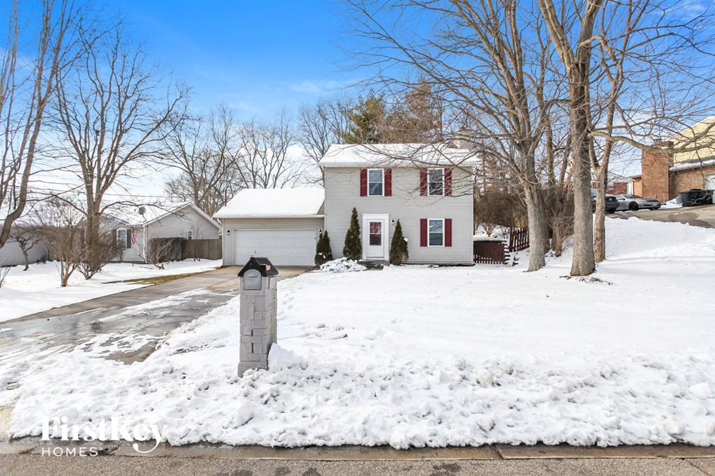 a white house with red shuttered windows in the snow
