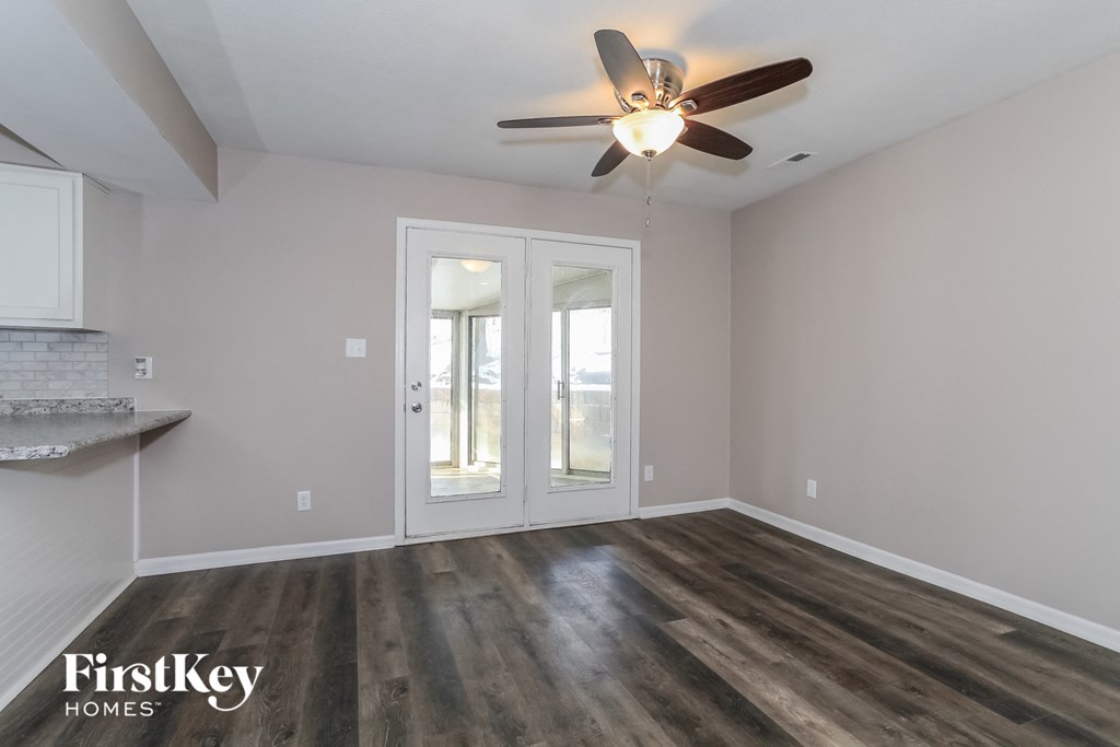 the living room of an empty house with a ceiling fan