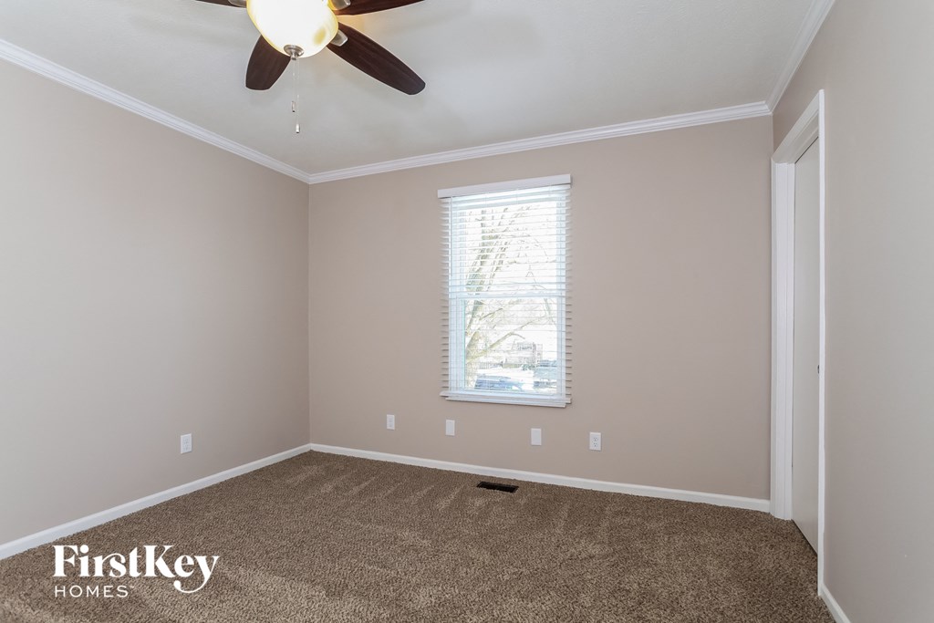 a empty room with a ceiling fan and a window