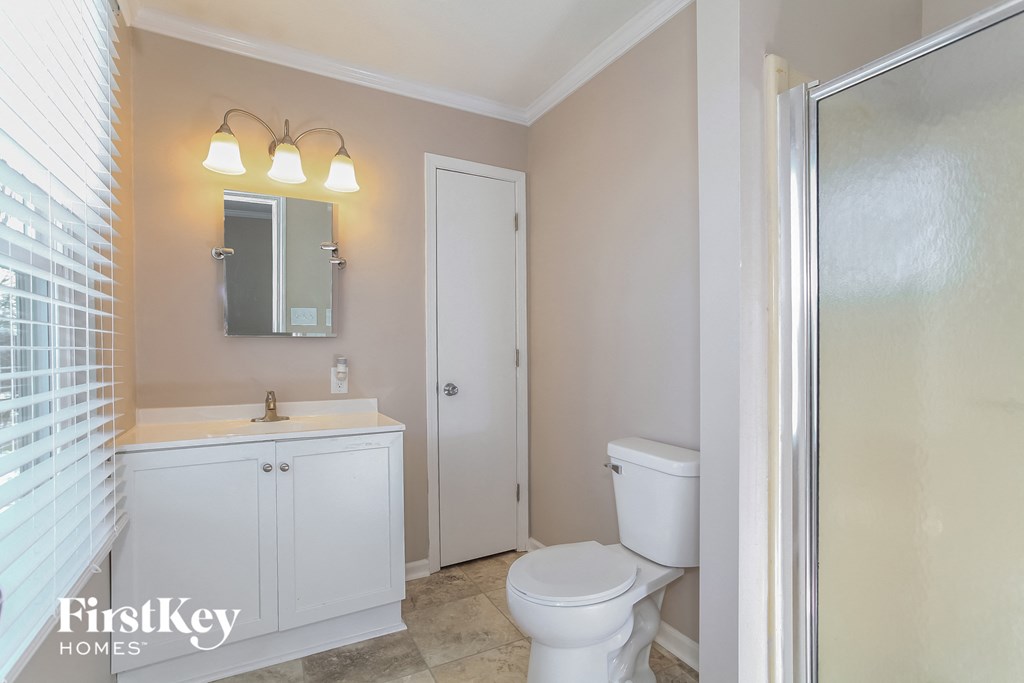 a bathroom with a toilet and a sink and a shower