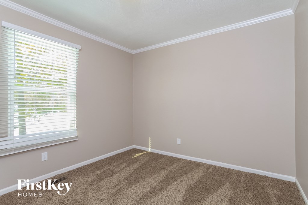 an empty room with carpet and a window