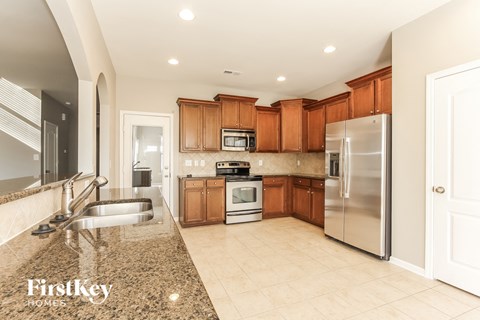 a kitchen with granite counter tops and wooden cabinets and stainless steel appliances