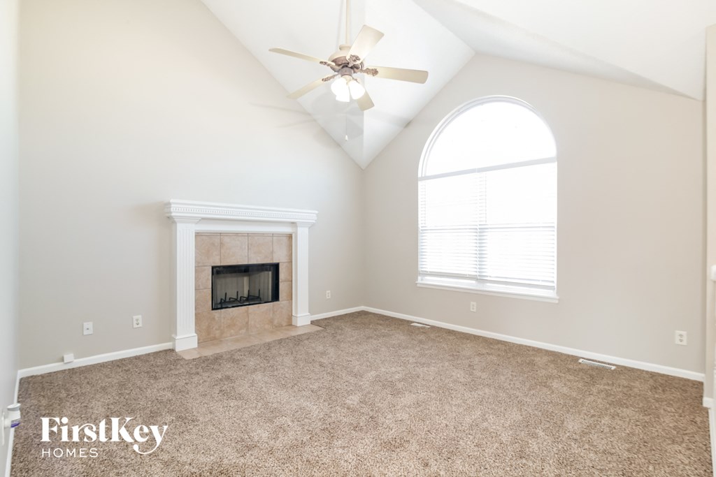 the living room with fireplace and ceiling fan