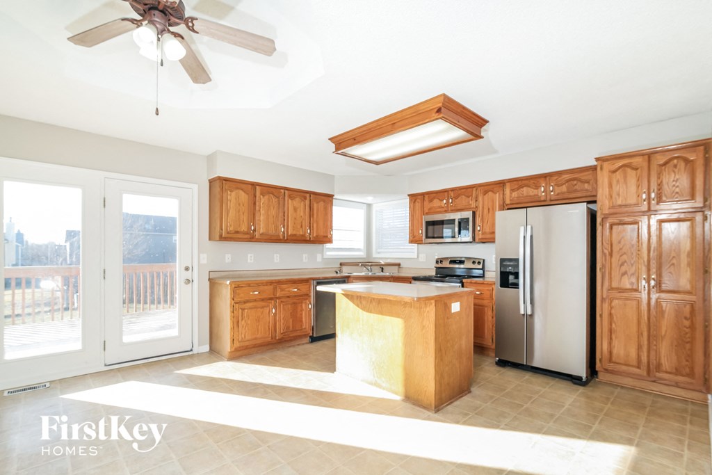 a large kitchen with wooden cabinets and stainless steel appliances