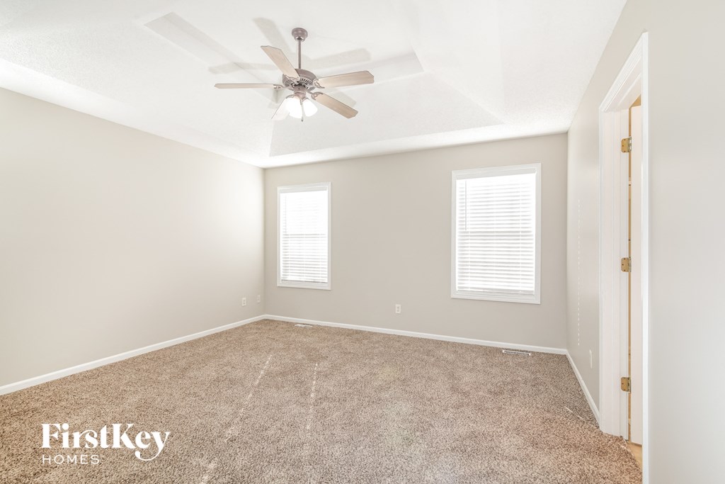 a bedroom with carpet and a ceiling fan