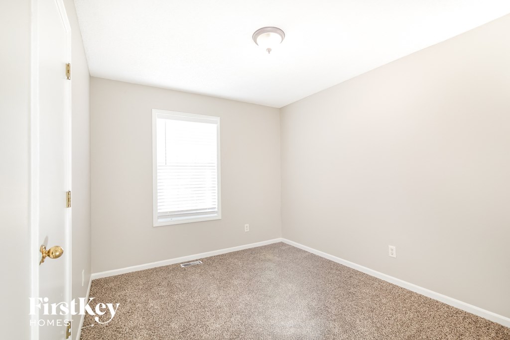 a bedroom with a carpeted floor and a window