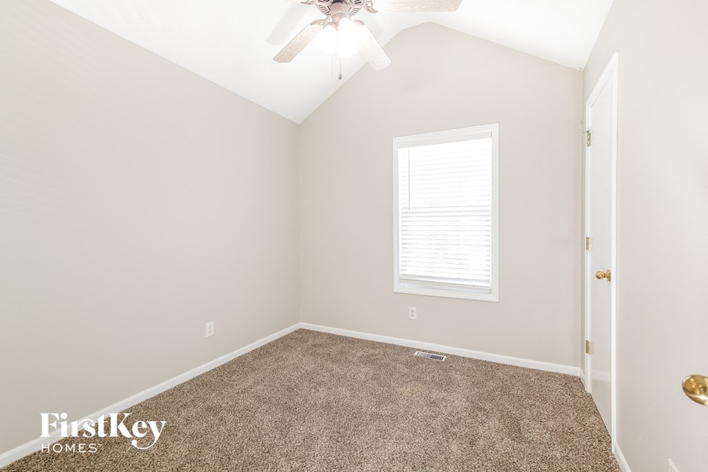 a bedroom with a carpeted floor and a window