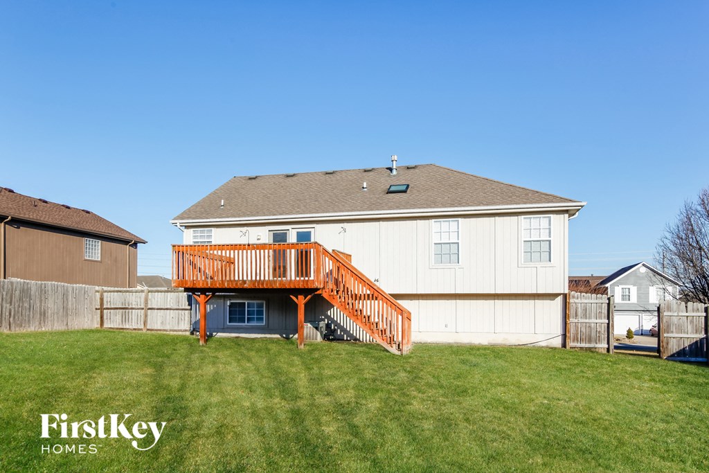 a backyard with a deck and a house with a wooden deck