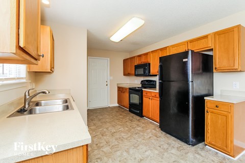 a kitchen with black appliances and wooden cabinets