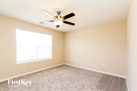 a bedroom with a ceiling fan and a window