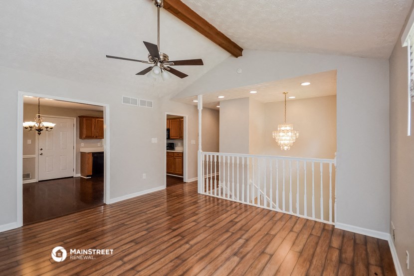 a living room with a staircase and a ceiling fan