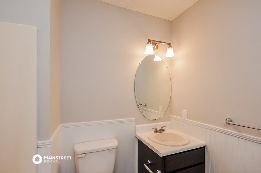 a bathroom with a toilet and a sink and a mirror