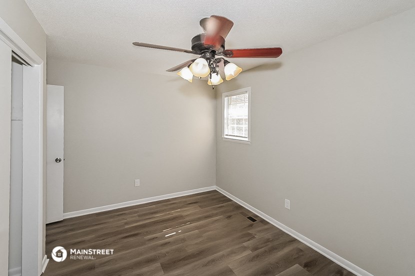 the interior of a bedroom with a ceiling fan