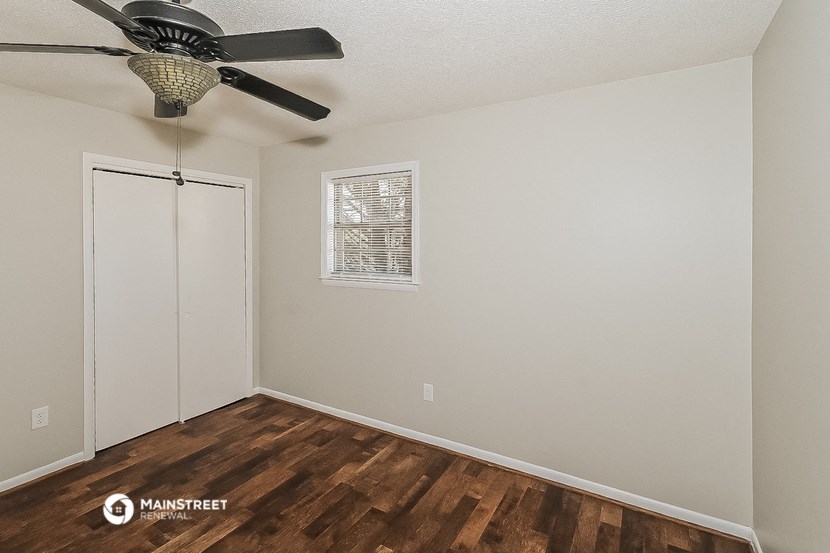 a bedroom with a ceiling fan and a closet