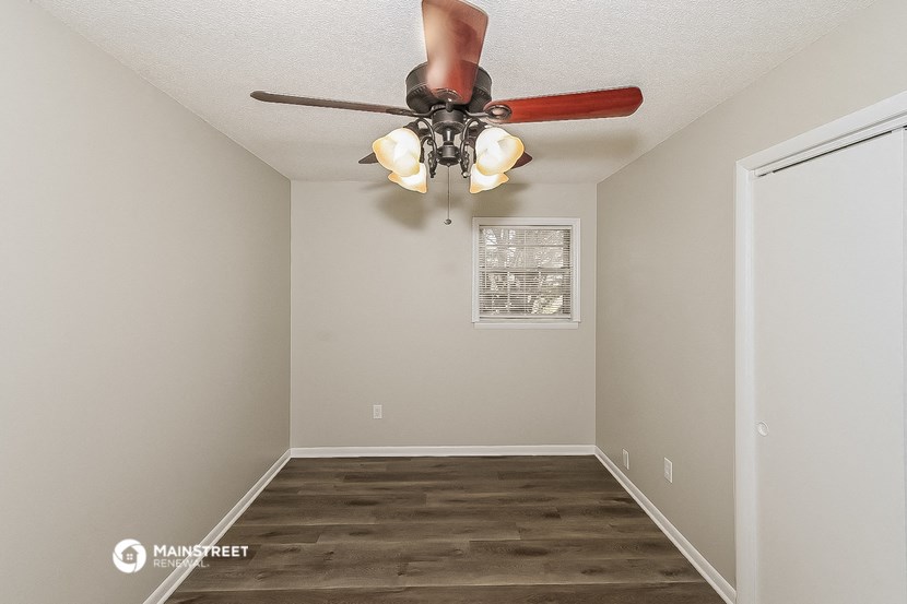 a bedroom with a ceiling fan and a window