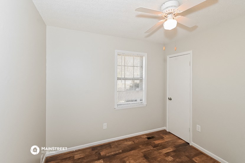 a bedroom with a ceiling fan and a door
