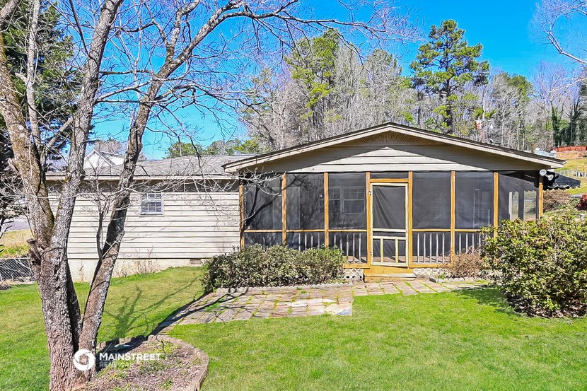 a small house with a porch and a grass yard