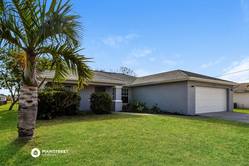 a white house with a palm tree in front of it