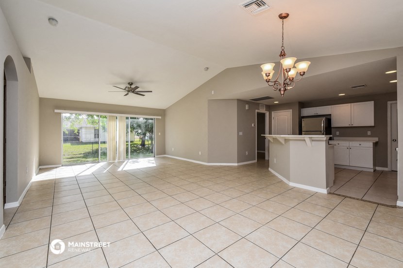 an open kitchen and living room with a sliding glass door to the backyard