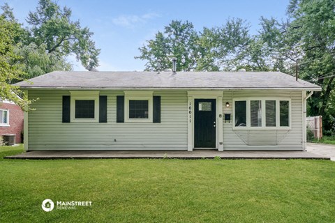the front of a white house with a porch and a lawn
