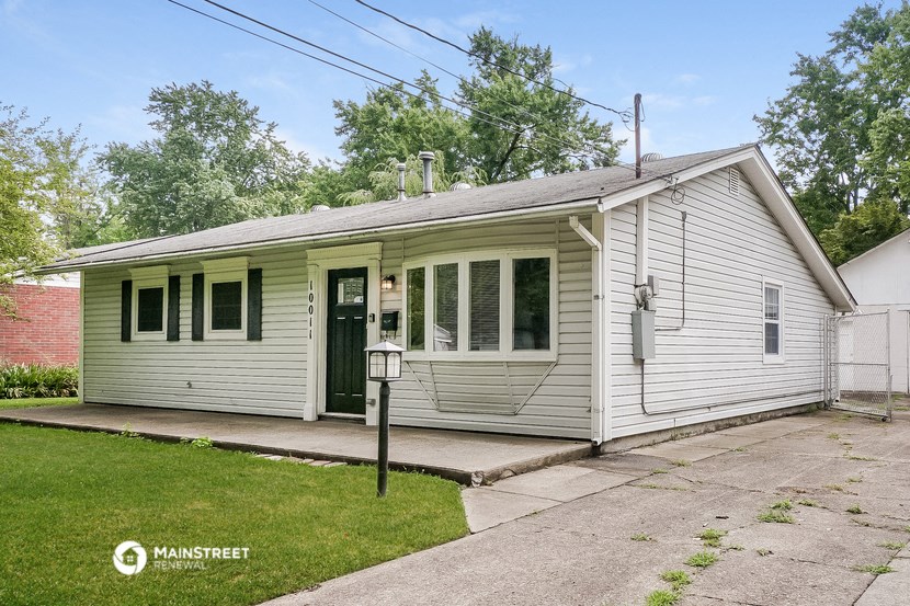 the front of a white house with a porch and a driveway