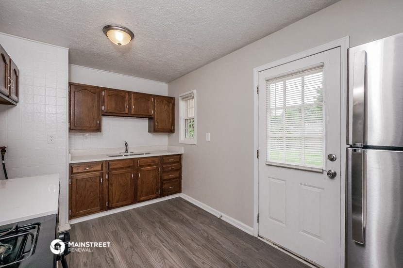 a kitchen with wooden cabinets and a stainless steel refrigerator