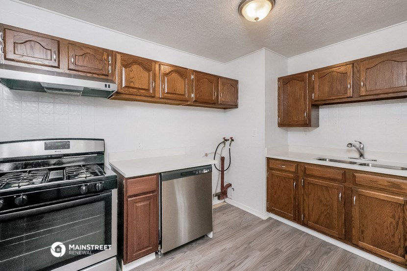 a kitchen with wooden cabinets and a stove and a dishwasher