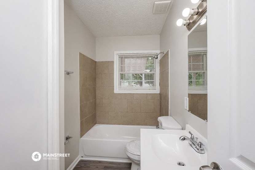 a bathroom with a tub and a sink and a mirror