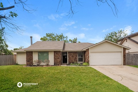 a brick house with a green door and a lawn