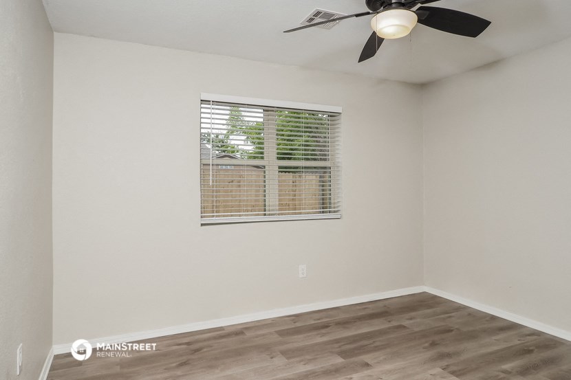 the living room of our studio apartment atrium with a window and a ceiling fan