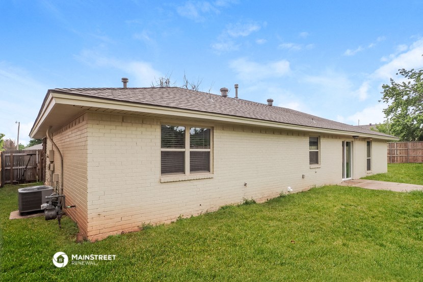 the exterior of a brick house with a yard and grass