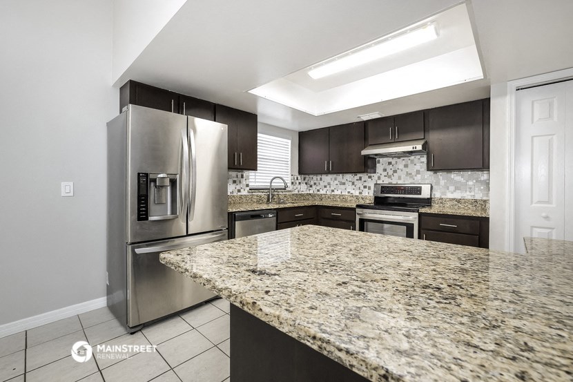 an updated kitchen with granite counter tops and stainless steel appliances