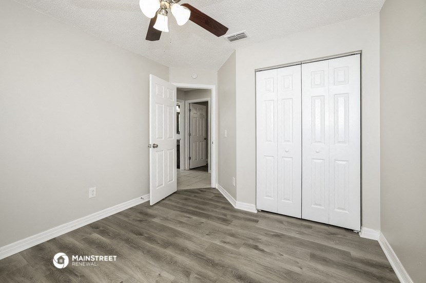 the living room of our studio apartment atrium with white walls and a ceiling fan