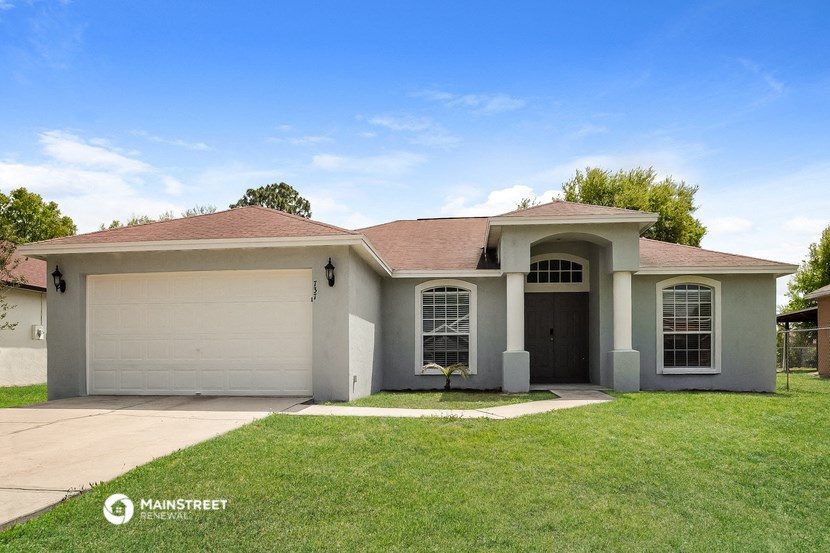 a white house with a lawn and a garage door