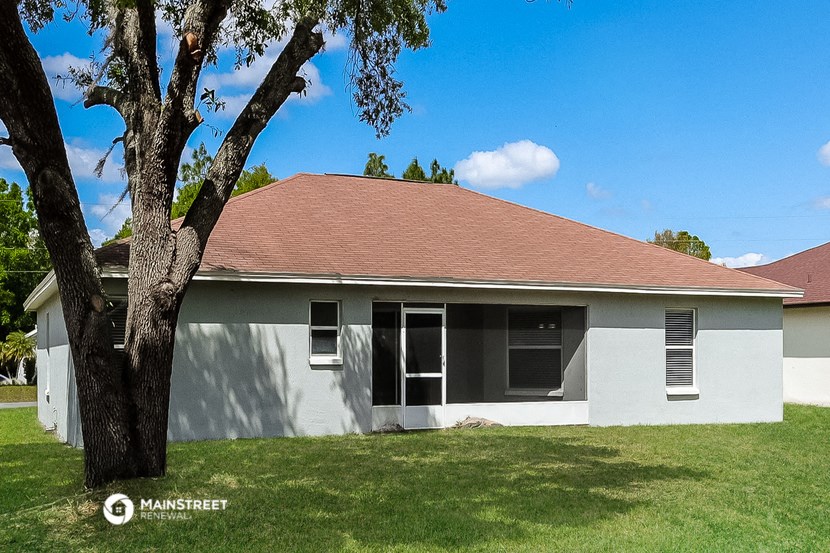 a small white house with a tree in front of it
