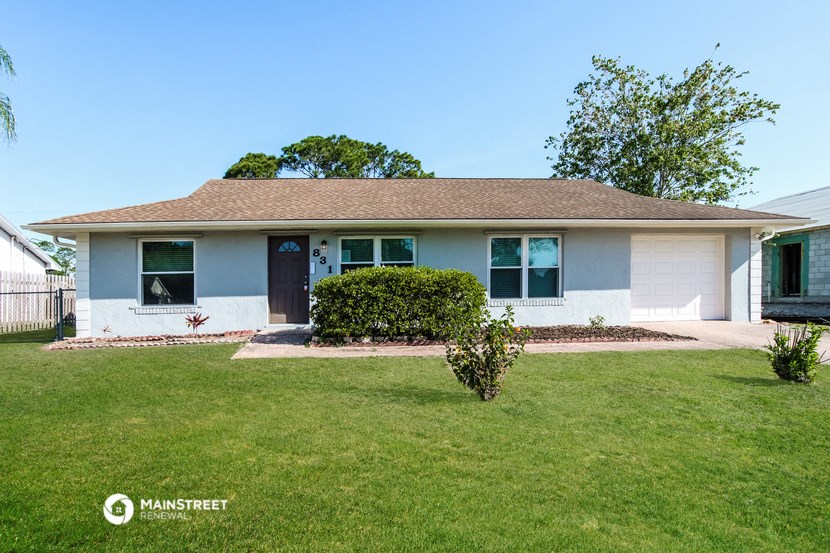 a white house with a lawn and a blue sky