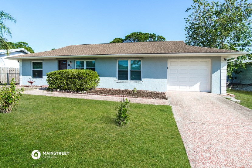 a white house with a lawn and a driveway