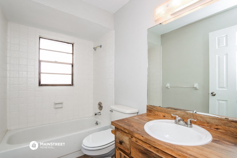 a bathroom with a sink toilet and tub and a mirror