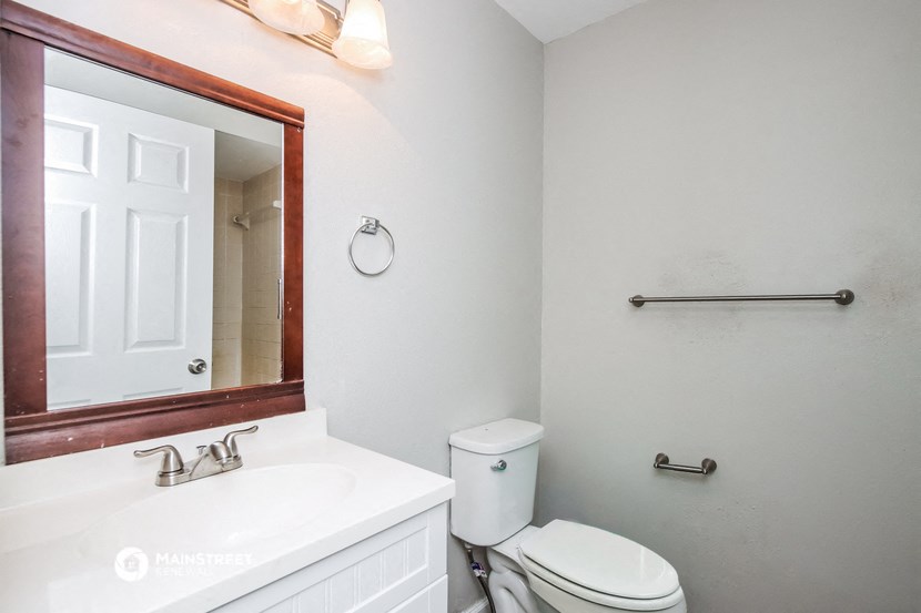 a bathroom with a toilet and a sink and a mirror