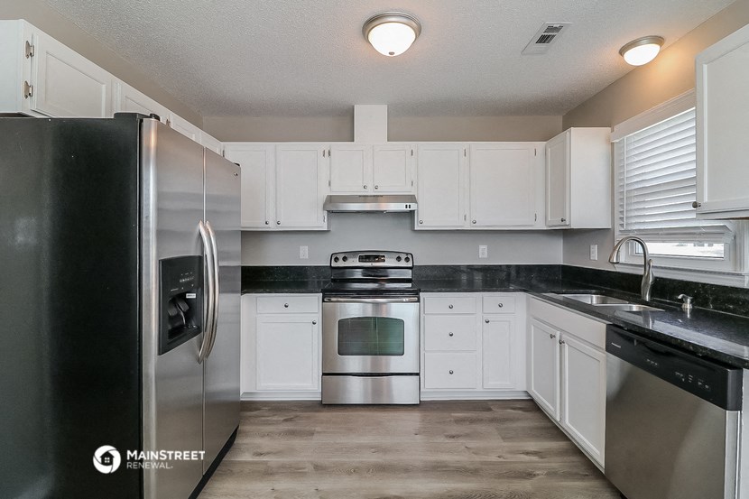 a kitchen with white cabinets and stainless steel appliances