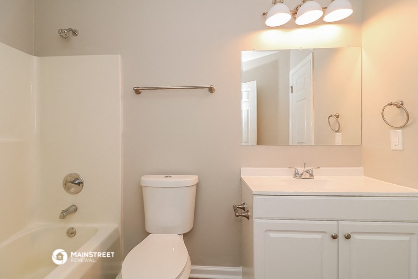 a bathroom with a toilet and a sink and a mirror