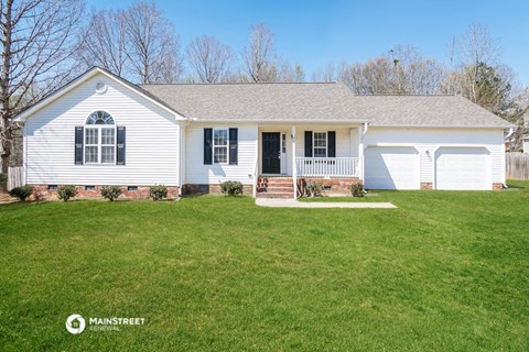 a white house with black shutters and a green lawn