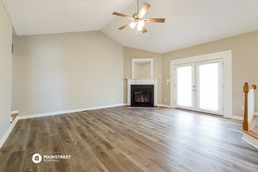 the living room with wood flooring and a fireplace