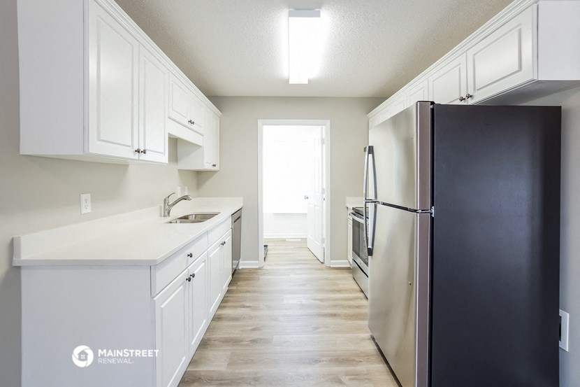 a white kitchen with stainless steel appliances and white cabinets